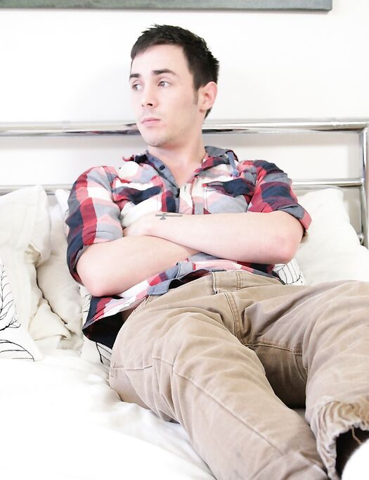 Gay brunette Justin Dean strips, grabs his huge dick and wanks it