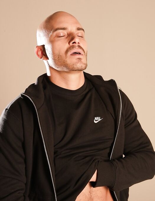 Bald gay hottie Yenier strips his black shirt and shows his stiff dick