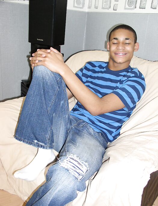 Sexy black gay Andrew smiles while stripping and masturbating in a solo